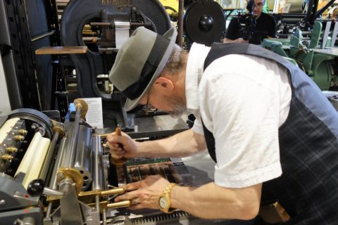 George A. Walker using a proof press to print lines of type from the Linotype machine